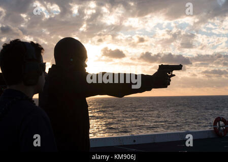 Derrick Elliott, de Bunnlevel en Caroline du Nord, pilote un pistolet de 9 mm tandis que son entraîneur de ligne, le lieutenant Andrew, qui déborde de St. Louis, observe un tir à armes légères sur le pont de vol du navire de transport amphibie USS New York (LPD 21). New York, les composantes du Iwo Jima Amphiobie Ready Group et de la 26e unité expéditionnaire maritime mènent un exercice combiné d'unité d'entraînement composite qui est le point culminant de l'entraînement de l'équipe Marine-Marine corps et qui les certifiera pour le déploiement. (É.-U. Marine Banque D'Images