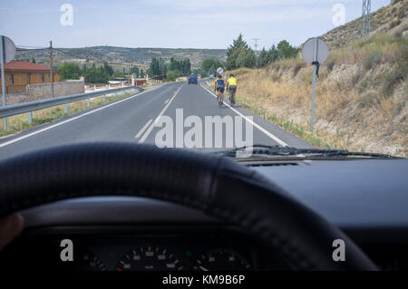 Conduire lentement derrière les cyclistes aux route locale. Vue depuis l'intérieur de la voiture Banque D'Images