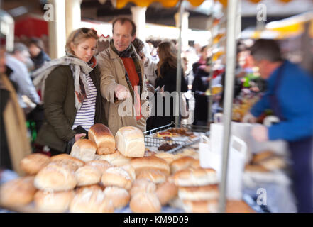 Choisir un couple de pain artisanal sur un stand au marché des fermiers de Stroud primé dans le Gloucestershire, Royaume-Uni Banque D'Images