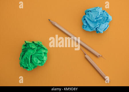 Crayon cassé et colorée des boules de papier froissé sur un fond jaune. close up. Banque D'Images