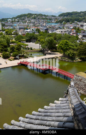 Matsumoto - le Japon, le 6 juin 2017 : rouge pont sur les douves du château de Matsumoto, également connu sous le nom de Château-de-Corbeau. Banque D'Images