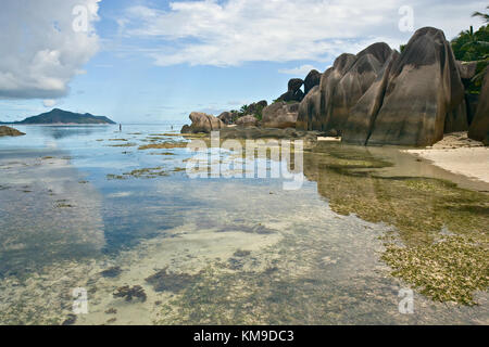 Anse Source d'argent lagoon sur l'île de la digue, seychelles. Les roches de granit typique et du ciel se reflétant dans la mer. Banque D'Images