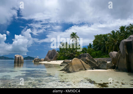 Anse Source d'argent lagoon sur l'île de la digue, seychelles. Les roches de granit typique et du ciel se reflétant dans la mer. Banque D'Images