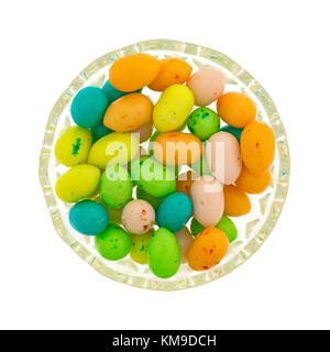 Vue de dessus d'un petit bol en verre rempli d'oeufs de Pâques colorés candy bubble gum isolé sur un fond blanc. Banque D'Images