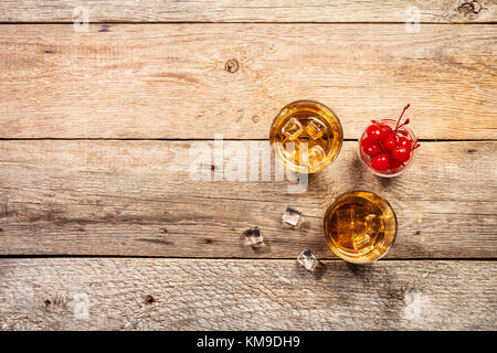 Whisky avec glace en glassesand cerise sur fond de bois rustique, vue supérieure avec copie espace Banque D'Images