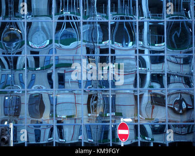 Motif créé par no entry sign & réflexions déformées en bleu panneaux vitrés sur façade de bâtiment neuf, Salford Quays, Manchester, Royaume-Uni Banque D'Images