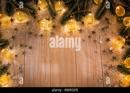 Noël arrière-plan avec une guirlande lumineuse blanche sur table en bois avec les branches de l'arbre de Noël, des étoiles et de la neige. maison de vacances idée pour l'hiver po Banque D'Images