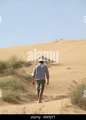 Homme marchant dans le désert sur une dune de sable Banque D'Images