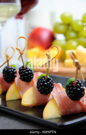 Canape de peach avec jambon séché et les mûres Banque D'Images