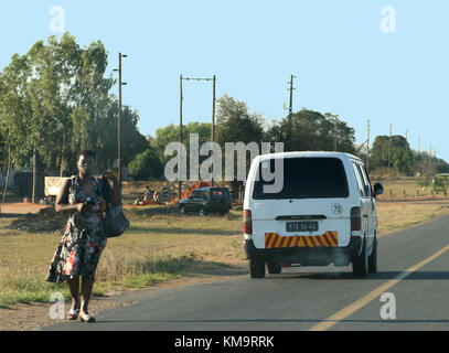 Maputo, Mozambique, dame de marcher sur le côté de la route Banque D'Images