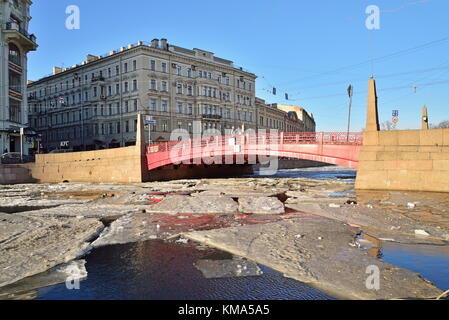 Pont Rouge illuminée par le soleil à travers la Rivière Fontanka et sa réflexion parmi les glaces au printemps Banque D'Images