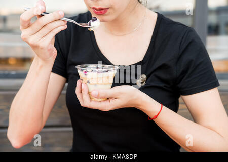 Femme mange un dessert avec des bleuets dans le Banque D'Images