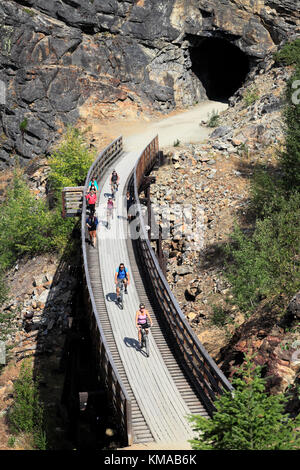 Les cyclistes le long de la piste cyclable, chevalets en bois du canyon Myra Myra Canyon, Ville, région de l'Okanagan, Kelowna, Colombie-Britannique, Canada. Banque D'Images