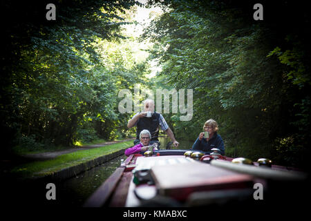 Deux femmes et un homme prendre un verre de thé tout en se tenant à l'arrière de leur grand classique sur le Birmingham & Fazeley Canal, Staffordshire, Angleterre. Banque D'Images