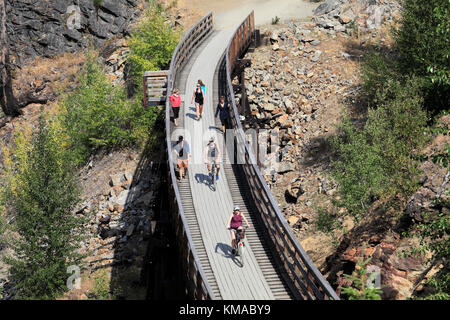 Les cyclistes le long de la piste cyclable, chevalets en bois du canyon Myra Myra Canyon, Ville, région de l'Okanagan, Kelowna, Colombie-Britannique, Canada. Banque D'Images