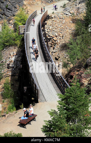 Les cyclistes le long de la piste cyclable, chevalets en bois du canyon Myra Myra Canyon, Ville, région de l'Okanagan, Kelowna, Colombie-Britannique, Canada. Banque D'Images