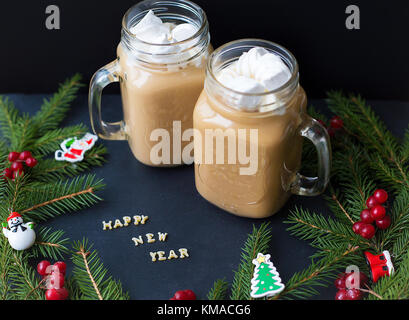 Marshmellou le cacao, l'arbre de Noël avec des décorations sur un fond noir. l'inscription Bonne année Banque D'Images