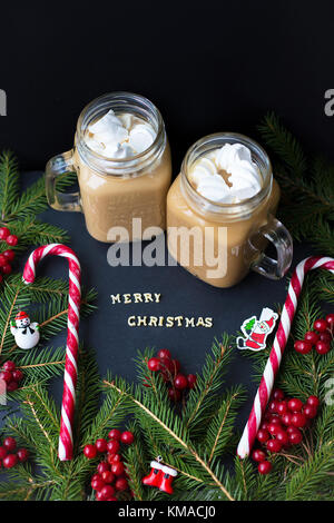 Du chocolat chaud et des bonbons marshmellou sur le fond d'arbres. l'inscription joyeux noël Banque D'Images