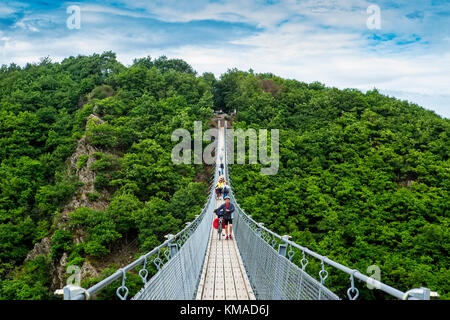 Geierlay, Morsdorf, Allemagne - 11 juillet 2017 : l'Allemagne croix vacanciers corde le plus long pont suspendu de 300 pieds au-dessus d'un canyon Geierley. Il i Banque D'Images