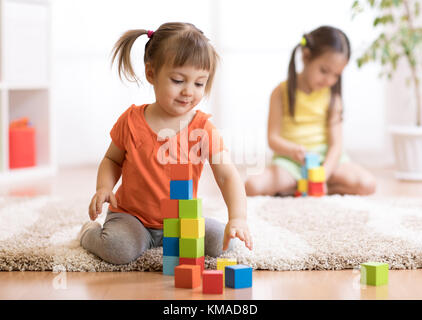 Les enfants jouant dans les jouets de bloc de jeux at nursery Banque D'Images
