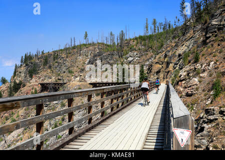 Les cyclistes le long de la piste cyclable, chevalets en bois du canyon Myra Myra Canyon, Ville, région de l'Okanagan, Kelowna, Colombie-Britannique, Canada. Banque D'Images