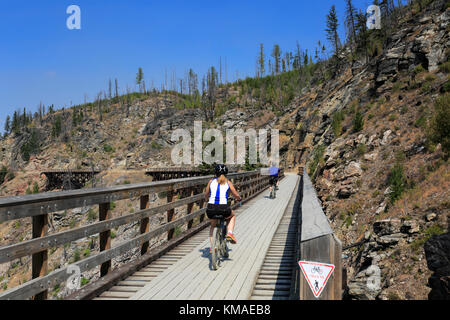 Les cyclistes le long de la piste cyclable, chevalets en bois du canyon Myra Myra Canyon, Ville, région de l'Okanagan, Kelowna, Colombie-Britannique, Canada. Banque D'Images