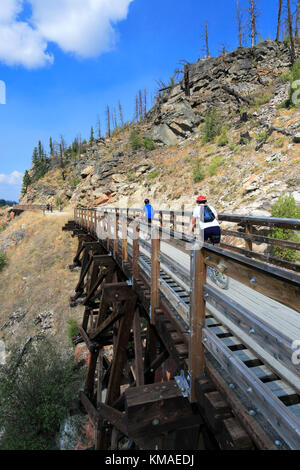 Les cyclistes le long de la piste cyclable, chevalets en bois du canyon Myra Myra Canyon, Ville, région de l'Okanagan, Kelowna, Colombie-Britannique, Canada. Banque D'Images