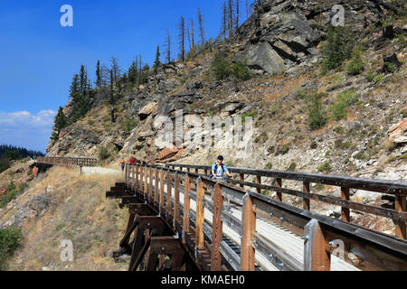 Les cyclistes le long de la piste cyclable, chevalets en bois du canyon Myra Myra Canyon, Ville, région de l'Okanagan, Kelowna, Colombie-Britannique, Canada. Banque D'Images