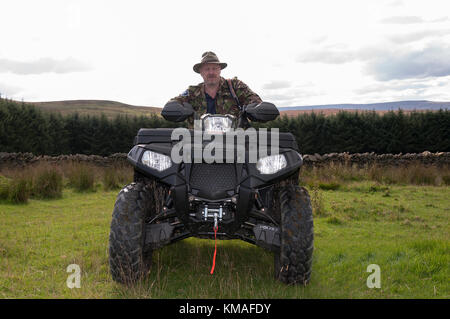 Un homme assis sur un quad (VTT) lors d'un voyage de chasse à Weardale dans le comté de Durham, au nord-est de l'Angleterre. Banque D'Images