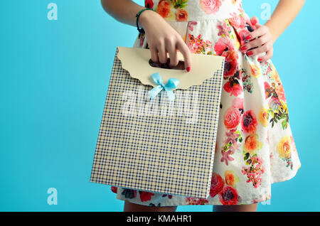 Close up femme mains tenant un carton élégant panier. studio photo conceptuelle isolé sur le fond bleu. Banque D'Images