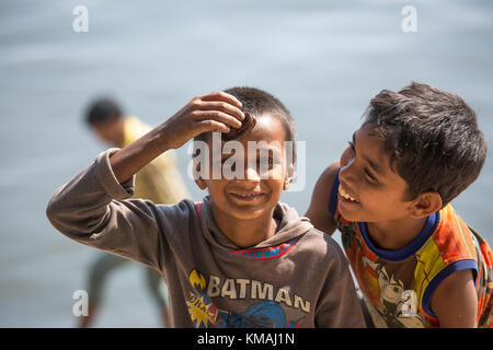 Deux enfants jouant baim(l) l'anguille poisson bébé à côté d'une rivière en burigonga ville de Dhaka. Banque D'Images