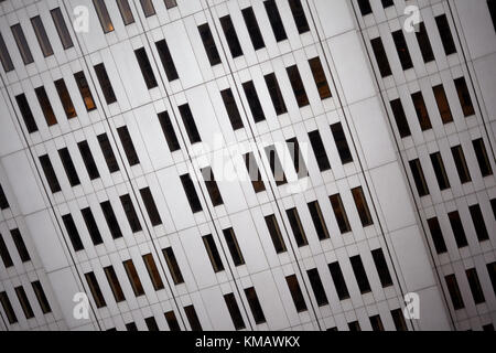 Voir l'angle incliné d'un immeuble commercial façade avec rangées de longues fenêtres étroites dans un mur blanc Banque D'Images