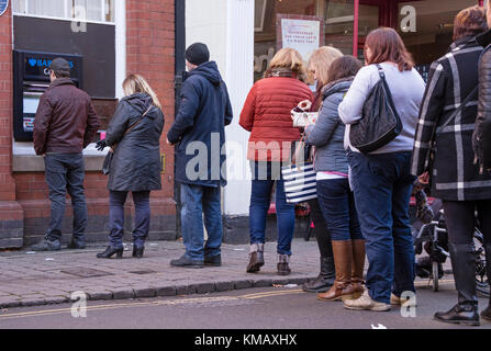 Une queue à un distributeur de billets de la rue haute, England, UK Banque D'Images