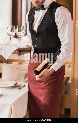 Waiter holding wineglasses et bouteille Banque D'Images