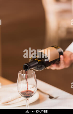 Waiter pouring red wine Banque D'Images