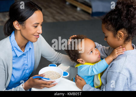 Mère et fille nourrir bébé Banque D'Images