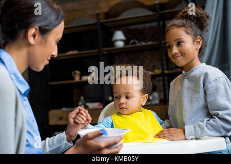 Mère et fille nourrir bébé Banque D'Images