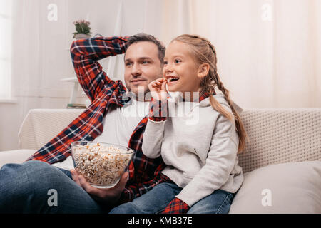 Père et fille eating popcorn Banque D'Images