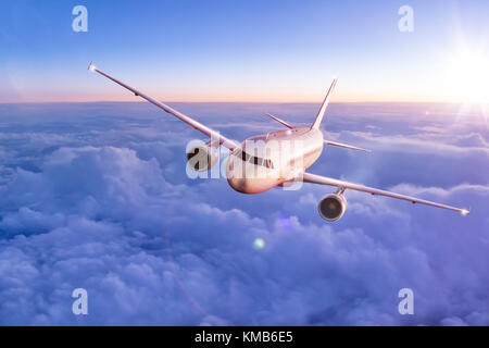 Avion volant au-dessus des nuages dans la lumière au coucher du soleil spectaculaire. haute résolution d'image. concept de transport et de déplacement rapide Banque D'Images