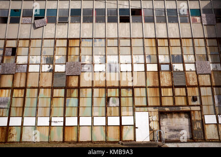 Faible angle vue de la façade d'une ancienne usine industrielle ou bâtiment avec des fenêtres cassées et structure rouillée Banque D'Images