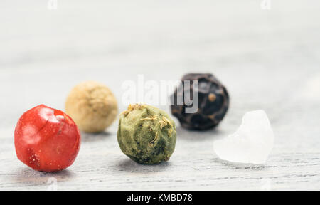 Extreme close-up view of poivre et sel sur table en bois gris. Divers grains de poivre de couleur avec l'exemplaire de l'espace. Concept de cuisson. Banque D'Images