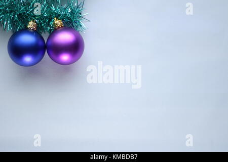 Décorations de Noël sur un morceau de guirlande verte sur un fond blanc en laissant une grande place pour écrire un message Banque D'Images