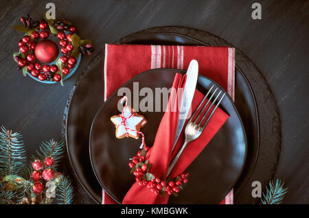 Concept menu de Noël sur fond sombre. Les plaques noires et des couverts vintage avec des décorations de noël en vert et rouge. Banque D'Images