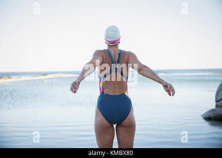 L'eau libre féminin s'étendant de l'océan au nageur Banque D'Images