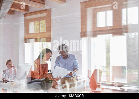 Business people discussing paperwork in office Banque D'Images