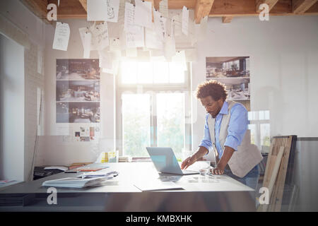 Homme graphic designer working at laptop in office Banque D'Images