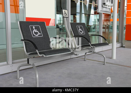 Deux sièges pour les personnes handicapées dans le hall de l'aéroport moderne. Banque D'Images