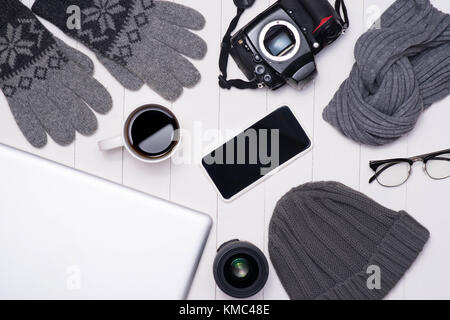 Hiver hommes tenues décontractées avec appareil photo, tasse de café, ordinateur portable, smartphone et lunettes sur fond de bois Banque D'Images