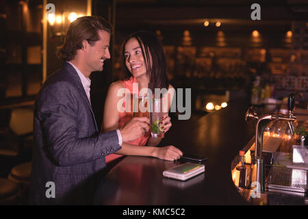 Couple toasting verres de boissons au comptoir Banque D'Images