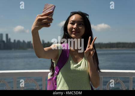 Femme asiatique prenant un selfie dans le ferry Banque D'Images